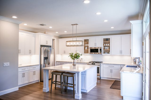a-kitchen-with-white-counters-and-cabinets-and-large-central-island
