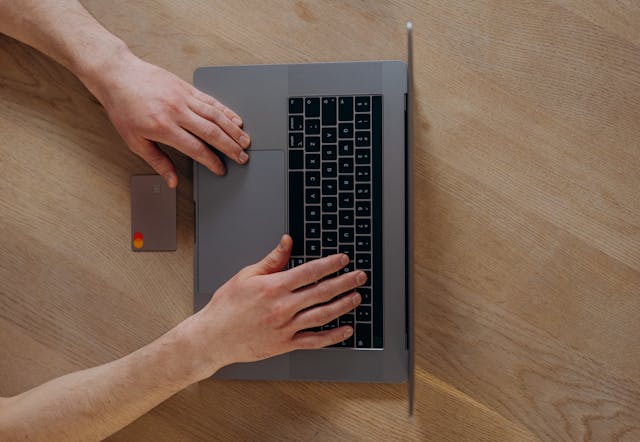 a-person-using-a-credit-card-and-laptop-to-make-an-online-payment
