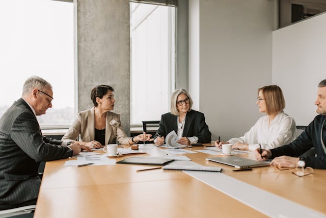 five-people-sitting-in-a-conference-room-having-a-meeting