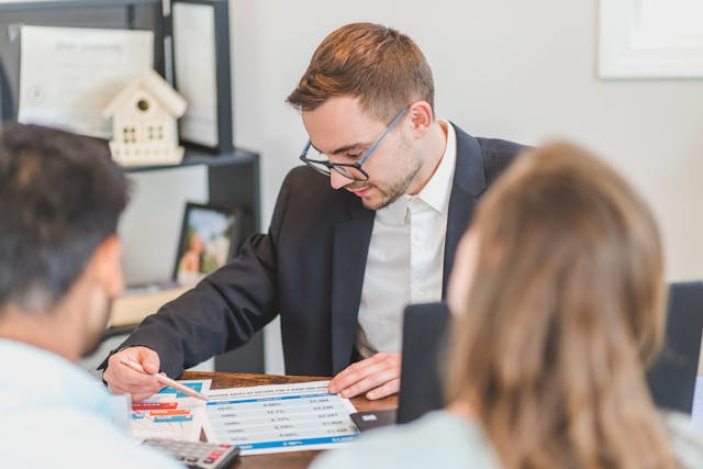 two-people-speaking-with-a-real-estate-expert-in-their-office