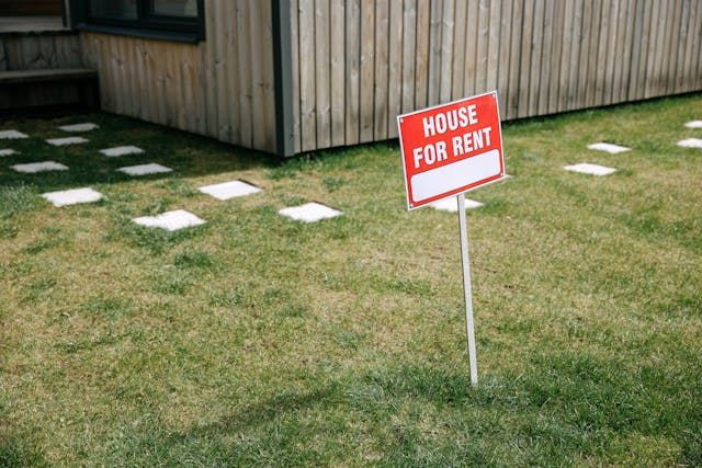a-red-for-rent-sign-in-a-front-yard