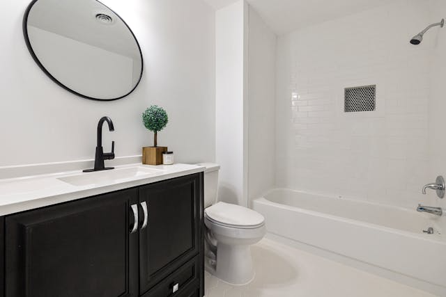 a-small-white-bathroom-with-a-dark-wood-vanity a-small-white-bathroom-with-a-dark-wood-vanity