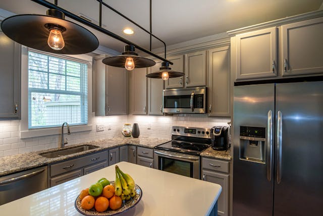 a kitchen with dark cabinets and counters and with modern appliances