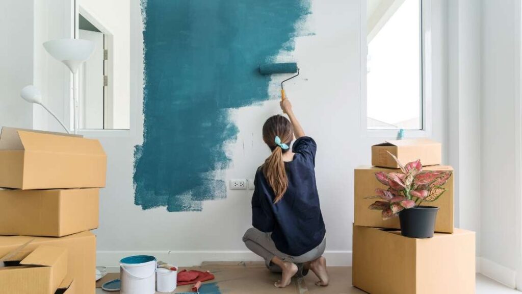 person painting a wall blue