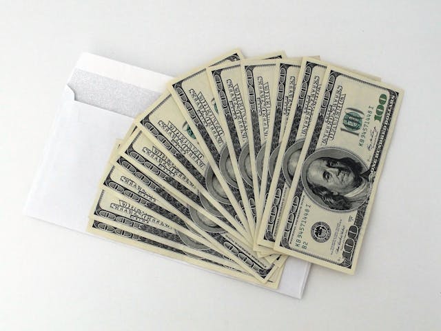 a bunch of money on white envelope