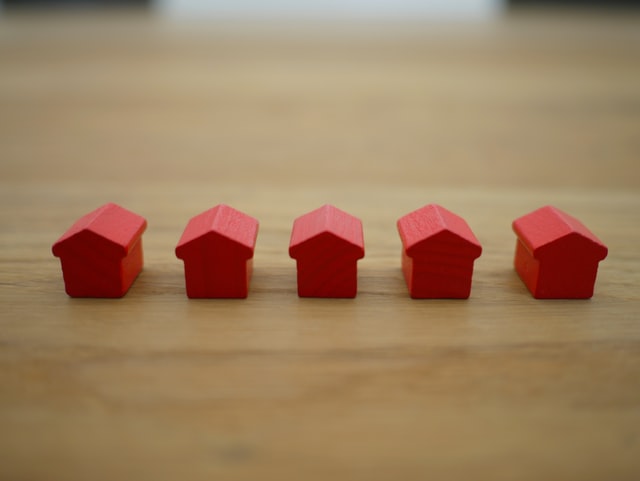 a bunch of red house figurines in a row