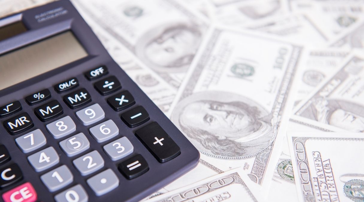 a calculator on a bunch of cash