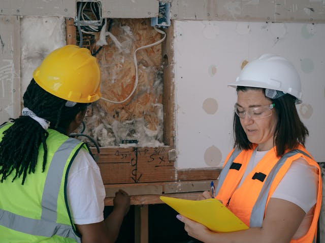 a contractor inspecting a homes insulation in their walls